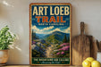 A vintage-style poster of the Art Loeb Trail in North Carolina, featuring a scenic mountain landscape with a winding path and colorful wildflowers.