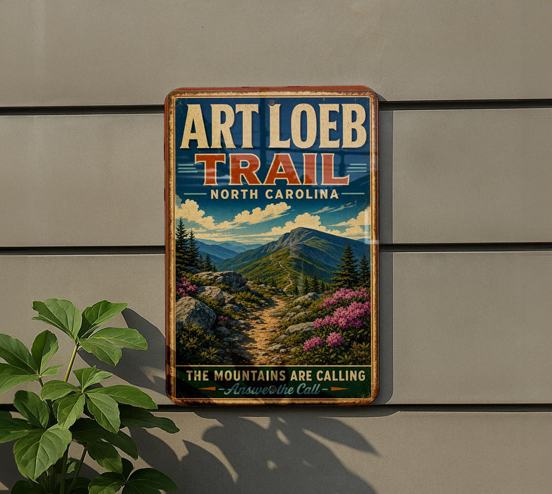 A vintage-style metal sign for the Art Loeb Trail in North Carolina, featuring a scenic mountain landscape with pine trees and a winding trail.