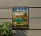 A vintage-style metal sign for the Ash Meadows National Wildlife Refuge in Nevada, featuring a desert landscape with a bird and a river.