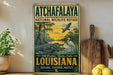 A vintage-style metal sign for the Atchafalaya National Wildlife Refuge in Louisiana, featuring an illustration of wildlife in a tropical setting.