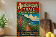 A vintage-style metal sign advertising the Awa'awapuhi Trail in Kauai, Hawaii, featuring a scenic mountain landscape with a path leading through it.