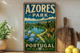 A vintage-style sign for "Azeros Park" in Portugal, featuring a scenic landscape with a lake, mountains, and colorful flowers.