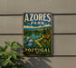 A vintage-style metal sign with the text "AZORES PARK PORTUGAL" displayed on a wall, featuring a scenic landscape with a lake, mountains, and colorful flowers.