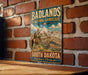 A vintage-style metal sign with the text "Badlands Cultural Landscape South Dakota" and an illustration of a cowboy on a horse, mounted on a brick wall.