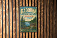 A vintage metal sign for Badoura State Forest in Minnesota, featuring a scenic illustration of pine forests and a lake.