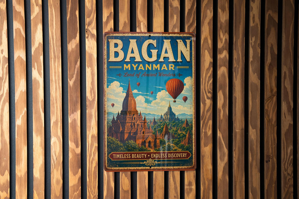 A vintage-style metal sign with the text "Bagan Myanmar" and a picture of a temple surrounded by hot air balloons, mounted on a wooden wall.