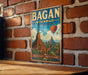 A vintage-style metal sign with the text "Bagan, Myanmar" and a picture of the famous Wat Arun temple in Bagan, Myanmar, is displayed on a brick wall.