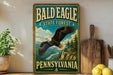 A vintage-style sign for the Bald Eagle State Forest in Pennsylvania, featuring an eagle in flight against a scenic landscape.