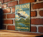 A vintage metal sign for the Bald Knob National Wildlife Refuge in Arkansas, featuring an eagle in flight and a scenic landscape.