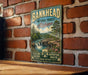 A vintage-style metal sign for the Bankhead National Forest in Alabama, featuring a scenic landscape with a waterfall and pine trees.