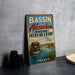 A vintage metal sign advertising Bassin d'Arçon, a fishing village in France, with a seascape and a small boat on the water.