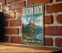 A vintage-style metal sign for Beacon Rock State Park in Washington, featuring a scenic mountain landscape with a lake and forest.