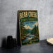 A vintage-style metal sign for Bear Creek State Forest in New York, featuring a scenic illustration of a forest and a river.