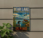 A vintage-style metal sign for Bear Lake National Wildlife Refuge in Idaho, featuring an illustration of various wildlife, including a moose, a loon, and a duck, set against a scenic landscape.