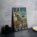 A vintage-style metal sign with a bird illustration and text, placed on a gray surface next to some black camera lenses.