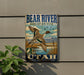 A vintage-style metal sign with a bird illustration, mounted on a wall next to a plant.