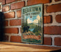 A vintage metal sign for the Beartown State Forest in Massachusetts, featuring a bear and a scenic landscape.