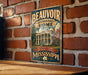 A vintage-style metal sign with the text "Beauvoir Jefferson Davis Home" displayed on a brick wall.