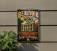 A vintage-style metal sign with the text "BEAUVOIR JEFFERSON DAVIS HOME" and "PRESERVING HISTORY HONORING A LEGACY MISSISSIPPI" is displayed on a wall, with a plant to the left.
