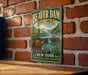 A vintage-style metal sign for Beaver Dam State Forest in New York, featuring a beaver in a dam surrounded by a forest landscape.