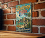 A vintage-style metal sign for Belitong Park, Indonesia, featuring a tropical beach scene with palm trees and rocks.