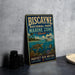 A vintage-style metal sign for Biscayne National Park, featuring an illustration of a turtle, coral, and fish, along with the text "PROTECT OUR WATERS EXPLORE PRESERVE".