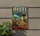 A vintage-style metal sign for the Bisti Badlands Trail in New Mexico, featuring a scenic illustration of the trail and rock formations.