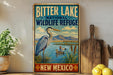 A vintage-style metal sign for the Bitter Lake National Wildlife Refuge in New Mexico, featuring an illustration of a heron and ducks in a lake.