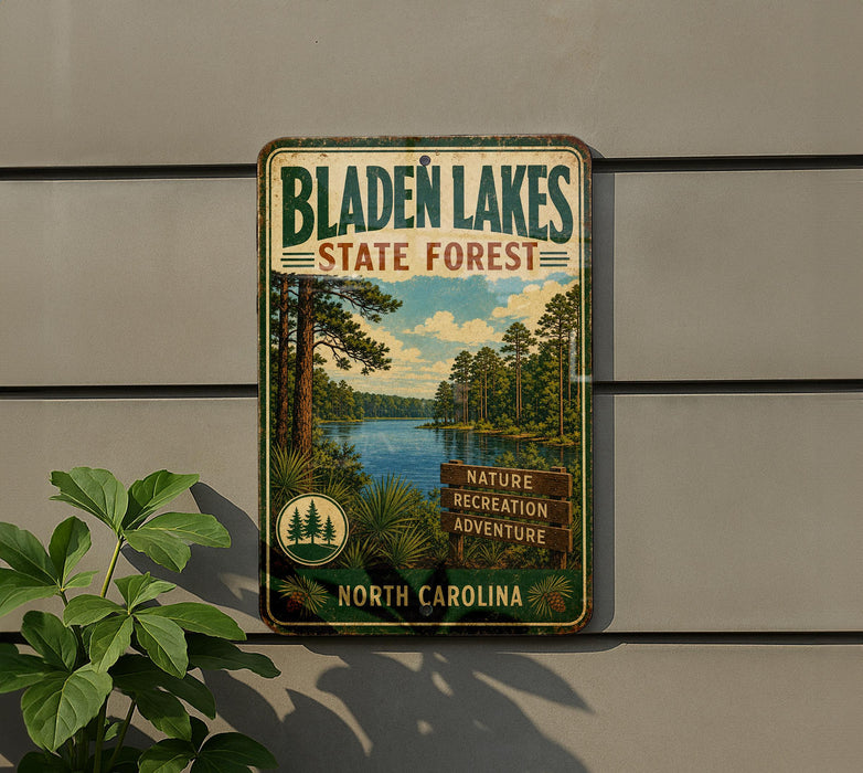 A vintage metal sign for Bladen Lakes State Forest in North Carolina, featuring a scenic image of the lake surrounded by pine trees and a blue sky.