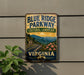 A vintage-style sign for the Blue Ridge Parkway in Virginia, featuring a scenic mountain landscape with a winding road and colorful flowers.