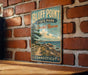 A vintage-style metal sign for Bluff Point State Park and Coastal Reserve in Connecticut, featuring a scenic coastal landscape with a lighthouse and a path leading to the beach.