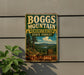 A vintage metal sign for Boggs Mountain, a demonstration state forest in California, featuring a scenic landscape with mountains, forests, and a lake.