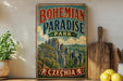 A vintage-style sign for Bohemian Paradise Park in Czechia, featuring a scenic landscape with mountains and trees.
