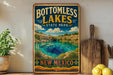 A vintage-style sign for Bottomless Lakes State Park in New Mexico, featuring a scenic landscape with a lake and mountains.
