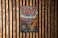 A vintage metal sign for the Bright Angel Trail in Arizona, featuring a scenic illustration of a hiker on a trail surrounded by mountains.