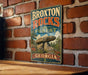 A vintage-style metal sign with the text "BROXTON ROCKS FOREST GEORGIA" is displayed on a brick wall.