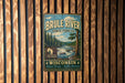 A vintage metal sign for the Brule River State Forest in Wisconsin, featuring a scenic landscape with a river, pine trees, and mountains.