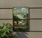 A vintage metal sign for the Brule River State Forest in Wisconsin, featuring a scenic illustration of the river surrounded by pine trees and a waterfall.