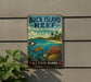A vintage-style metal sign for Buck Island Reef National Monument, featuring a tropical beach scene with palm trees, colorful coral, and a sea turtle swimming in the ocean.