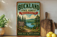 A vintage-style sign for Buckland State Forest in Massachusetts, featuring a scenic landscape with pine trees, a lake, and mountains.