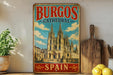 A vintage-style metal sign for the Burgos Cathedral in Spain, featuring an illustration of the cathedral and the text "Burgos Cathedral" in a colorful, decorative font.