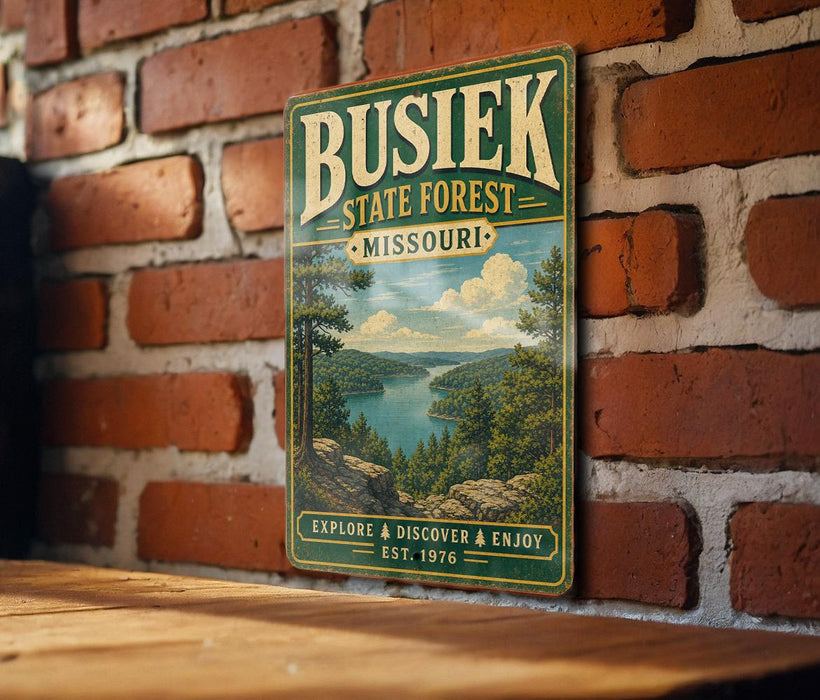A vintage-style metal sign for Busiik State Forest in Missouri, featuring a scenic landscape with a lake and mountains.