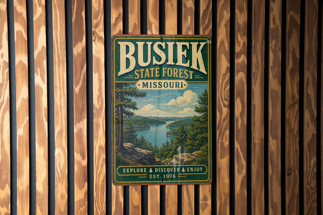 A vintage-style metal sign for Busiak State Forest in Missouri, featuring a scenic landscape with a lake and mountains.