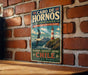 A vintage-style metal sign with text and an illustration of a lighthouse and a bird, mounted on a brick wall.