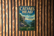 A vintage metal sign for Caesar's Head State Park in South Carolina, featuring a scenic mountain landscape.