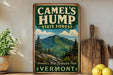 A vintage-style metal sign advertising Camelsump State Forest in Vermont, featuring a mountain landscape and pine trees.