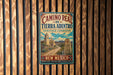 a vintage-style metal sign with a colorful illustration of a Mexican landmark, hanging on a wooden wall.