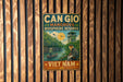 a vintage-style metal sign with a tropical scene, including a boat, a person, and a bird, hanging on a wooden wall.