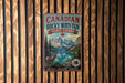 A vintage-style metal sign for Canadian Rocky Mountain Parks Canada, featuring a mountain landscape with a river and a bighorn sheep, mounted on a wooden wall.