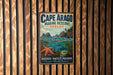 A metal sign for Cape Arago Marine Reserve, Oregon, featuring a scenic illustration of the ocean, mountains, and marine life.